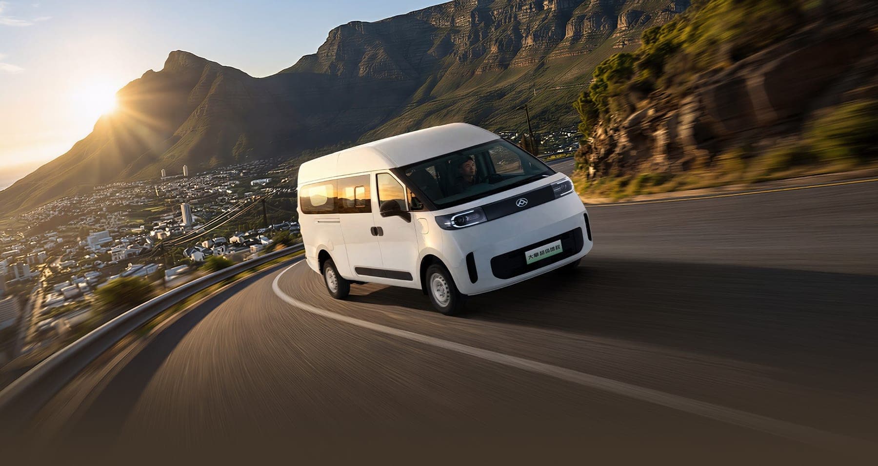 MAXUS Dana Super EREV Van 2026 — فان بضائع كهربائي بموسّع مدى للتصدير, منظر أمامي جانبي على طريق ساحلي