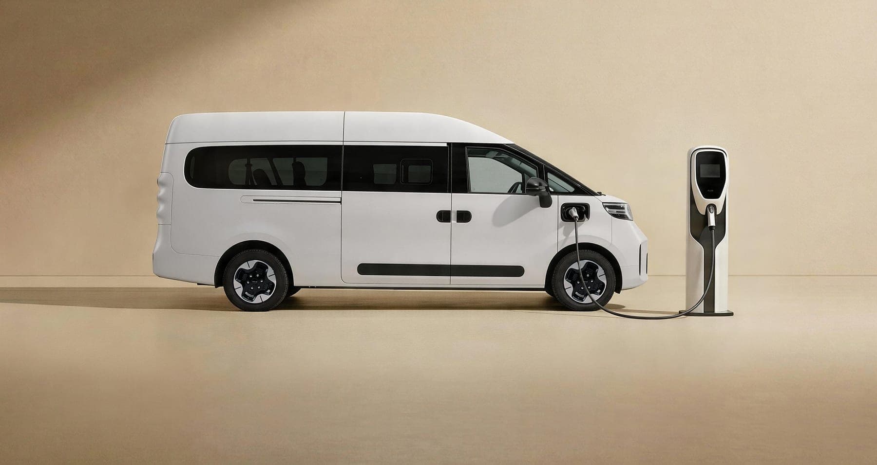 MAXUS Dana M1 Electric Van 2026 — فان ركاب كهربائي بتسعة مقاعد للتصدير, منظر جانبي أثناء الشحن في نقطة شحن DC
